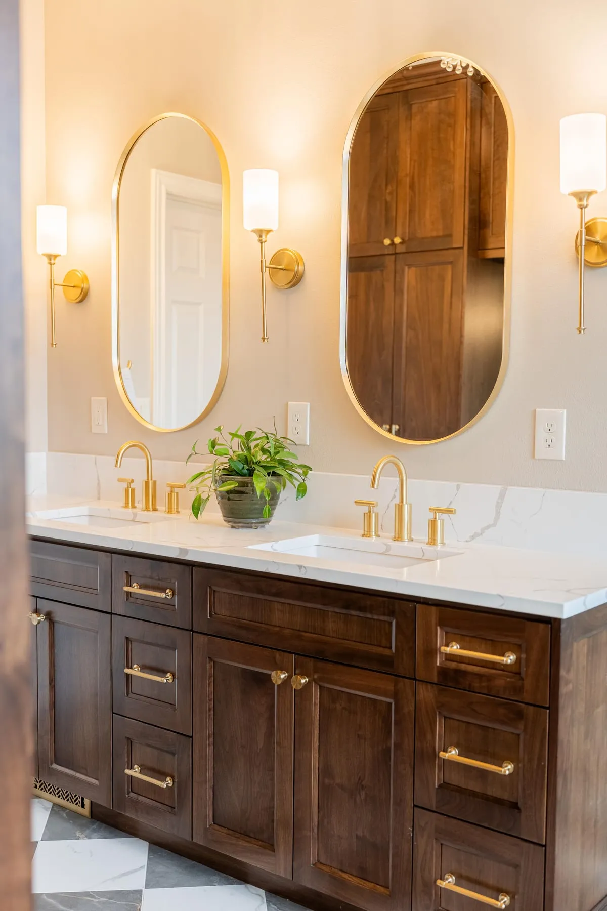 A custom oak vanity with brass fixtures and quartz counters by McCracken Projects in the Idaho Falls area