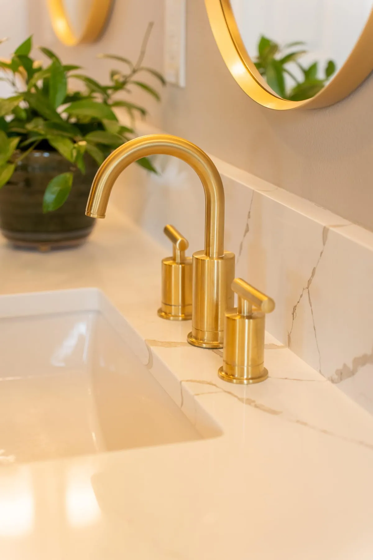 A brass faucet and quartz backsplash detail by McCracken Projects in the Idaho Falls area
